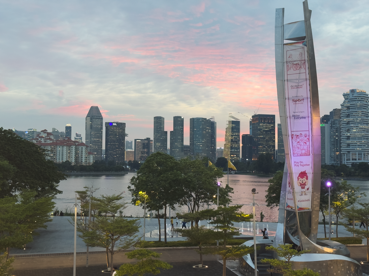 A stunning view of a modern citys skyline during twilight with a vibrant pink sunset.